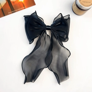 Macro shot of the layered black chiffon bow hair clip with flowing long ribbons