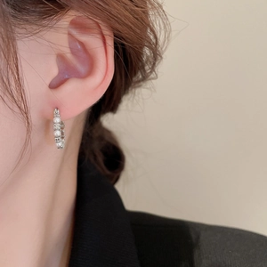 Silver C-shape hoop earrings with small pearls on model with minimalist design