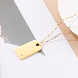 Macro shot of gold rectangle pendant with small diamond and delicate chain detail