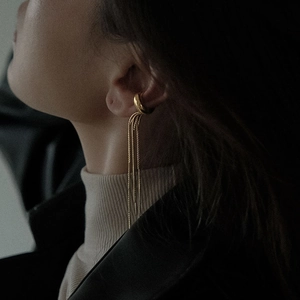 Close-up of gold stainless steel ear cuff with long tassel snake chains on a model
