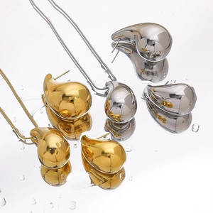 Polished 18K gold and silver teardrop jewelry set including earrings and necklace
