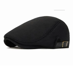 Dettaglio della coppola con cinturino in pelle nera e fibbia metallica vintage