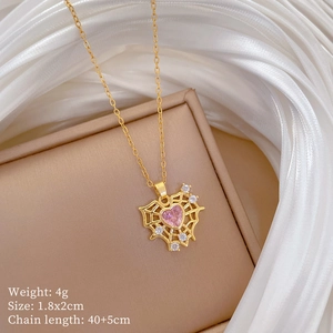Detail of spider web necklace with pink heart gem on silk and jewelry gift box