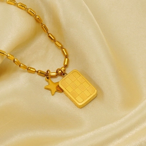 Vista macro della collana con ciondolo a stella e griglia dorata su elegante seta champagne