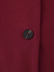 Detailed close-up of dark button on Angora Red wool coat fabric with visible texture