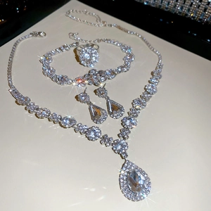 Detailed luxury silver jewelry set with teardrop crystals including necklace, bracelet, earrings, ring