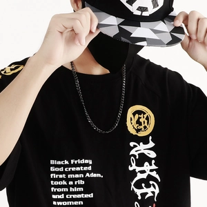 Close-up of black streetwear t-shirt with detailed gold and white graphic text patterns