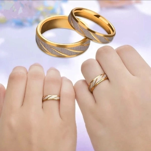 Golden and silver stainless steel couple rings with brushed finish and diagonal stripes