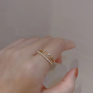 Close-up of stacked multi-layer gold rings with elegant pearls and cubic zirconia