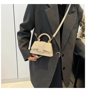 Détail de la texture d'un sac à main beige tissé avec poignée et boucle nouée élégante