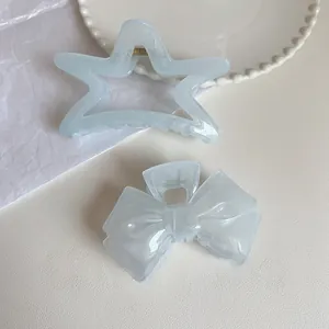 Detail of cream blue star and bow hair claws made of translucent acrylic material