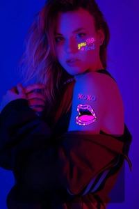 Détail d'un tatouage éphémère fluorescent rose fluo avec motifs de cœurs et de lèvres