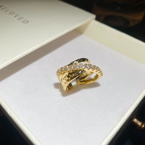 Macro shot of gold-plated triple layer ring with zircons and hammered texture in gift box