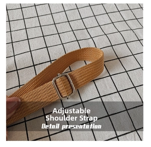 Detail showing an adjustable brown woven shoulder strap with a silver metal buckle