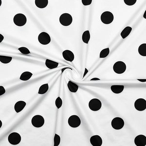 Vue détaillée du tissu à pois noirs et blancs avec texture douce et drapé élégant