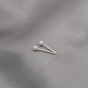 Macro view of S925 sterling silver stamp on minimalist white pearl stud earrings