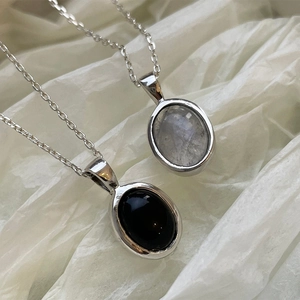 Detail of 925 silver necklaces with oval moonstone and black onyx pendants