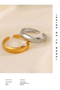 Detailed close-up of gold and silver domed open rings on elegant silk fabric background