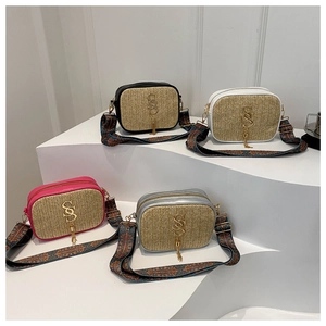 Group display of woven straw square bags with leather trim and ethnic style wide straps