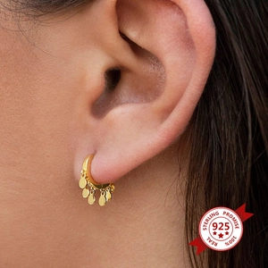 Detailed macro of gold S925 sterling silver tassel earrings with small metal discs