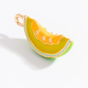 Vue détaillée du pendentif melon émaillé avec bordure dorée et tons vert-jaune