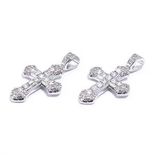 Detail view of two silver cross pendants with embedded clear crystals and hanging loops