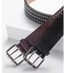Detailed close-up of punk style leather belts with metal studs and pin buckles