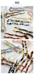 Macro view of multi-color acetate U-shaped hairpins with wavy curves and marble textures