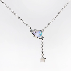 Macro detail of silver heart planet necklace with iridescent stone and star pendant
