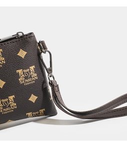 Close-up of litchi textured brown PU leather wallet with golden logo pattern and wristlet