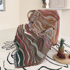 Detailed knit bohemian throw blanket with colorful abstract stripes and handmade tassels