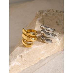 Three-layer 18k gold and silver spiral rings shown on natural stone display