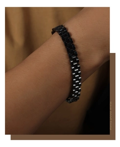 Detail of matte black stainless steel watchband style bracelet on a male wrist