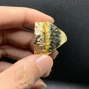 Detalle de anillo ancho chapado en oro de 14K con textura martillada y perfil lateral grueso