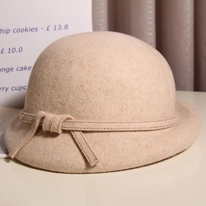 Close-up of beige wool cloche hat with a delicate bow and vintage rolled brim