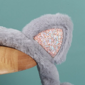 Detailed close-up of gray plush earmuffs with pink sequins and movable rabbit ears design