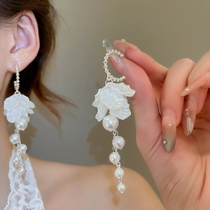 Elegant floral drop earrings with white petals and dangling gradient pearls on silver chains