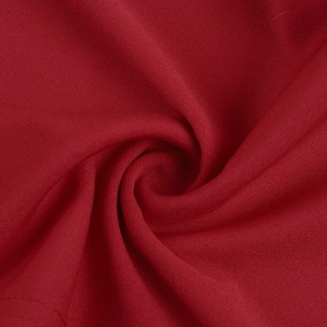 Detailed view of the luxury red satin fabric with a smooth texture and elegant spiral folds