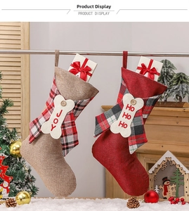Detail of Christmas stockings with JOY and HO HO HO embroidery and festive plaid bows