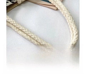 Detail of soft cream braided rope handles on a stylish houndstooth canvas tote bag