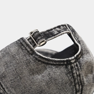 Macro view of adjustable metal buckle and washed denim texture on vintage baseball cap