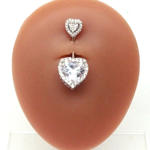 Detail of silver heart belly button ring with zircons on silicone navel model