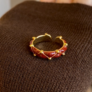 Macro shot of 24K gold-plated vintage ring with red enamel and pleated texture detail