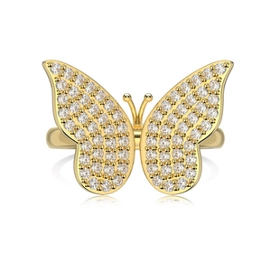Golden butterfly ring with sparkling zircons on a white reflective surface