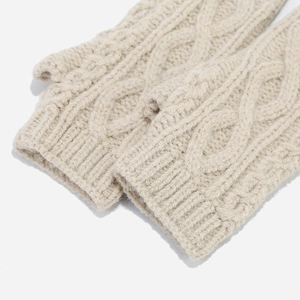 Detail of cream cable-knit fingerless gloves featuring thick yarn and ribbed cuffs