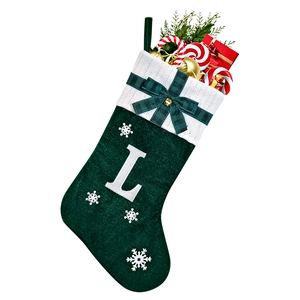 Detail of green velvet Christmas stocking with white letter L embroidery and bow