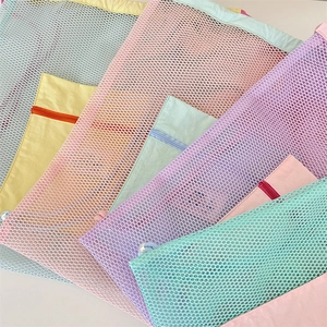 Vue détaillée de la maille respirante et des zips colorés sur les sacs à cordon légers