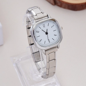 Macro shot of silver square dial quartz watch with stainless steel stretch band links