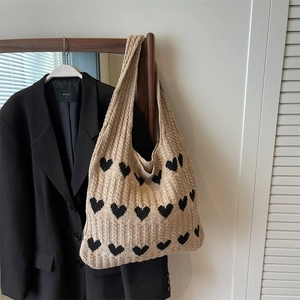 Knitted beige heart pattern tote bag displayed on a hanger for casual everyday styling
