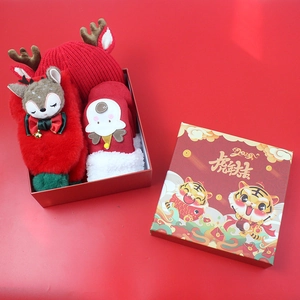 Close-up of kids Christmas gift set featuring red reindeer hat, gloves, and socks in a box